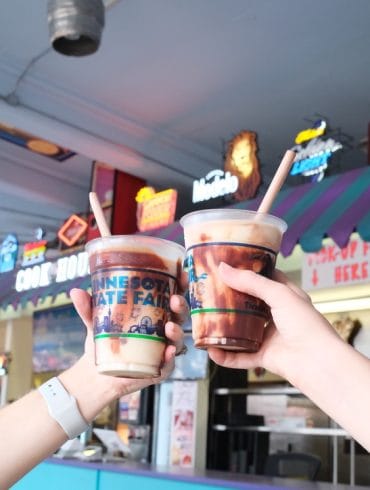 Two hands holding a blended ice cream beverage in each hand.
