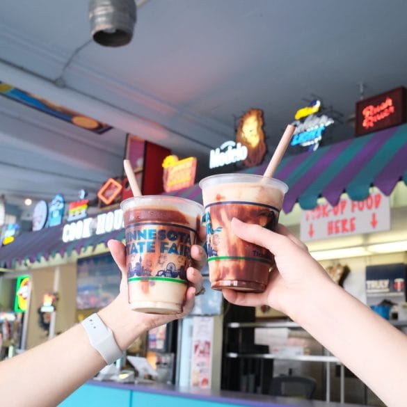 Two hands holding a blended ice cream beverage in each hand.